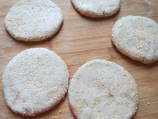 12、麻油芝麻驴肉火烧,面团沾均匀芝麻。在擀成圆饼。