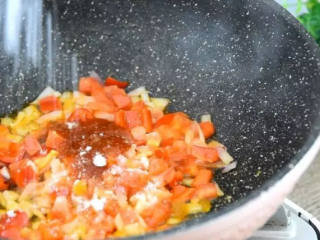 3、世界杯各国特色美食——西班牙海鲜烩饭,倒入番茄酱，盐、糖，炒匀