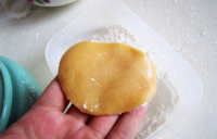 8、木糖醇山药&紫薯月饼,静置好的面团平均分成10份，每一分约10-15克，将面皮揉成球，在手中压扁