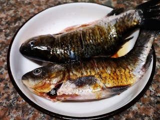 3、凉拌鲫鱼,给鱼身上均匀抹上盐再倒入适量蒸鱼豉油腌制20分钟。