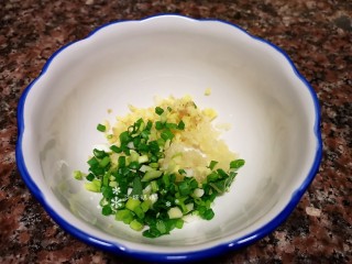 6、凉拌鲫鱼,将小葱大蒜和生姜碎放入碗中。
