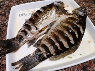 10、凉拌鲫鱼,蒸好的鱼将盘中的料汁倒入调料碗中后放凉。