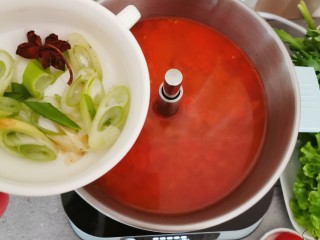 11、部队火锅,番茄酱倒入火锅中，添加适量清水，放入葱和八角。