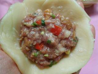 16、苏式萝卜干鲜肉月饼,把面团压扁擀成中间稍比边缘厚的面皮,放入适量馅料。