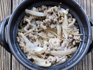 13、肥牛窝蛋砂锅,再放入肥牛洋葱,再把汤汁倒在米饭上,中间留一个蛋黄的空位