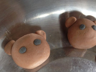 6、轻松熊汤圆,再将黑色面团取一丁点做眼睛，粘在上面