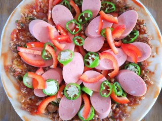 24、微波炉版美味披萨,再将切好的火腿肠和青红椒均匀放在面饼上