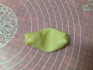 17、手捧着吃的――咖喱鸡肉月饼,取第一个第二次擀卷好后的面卷，平放，用拇指在中间压一下