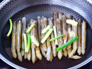 11、白灼刀把蛏子,先放入切段的小葱和姜片。