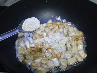 7、孜然小葱煎豆腐,再加入一勺芝麻。
