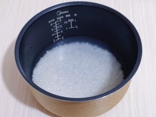 3、懒人煲仔饭--电饭煲版,泡好的米倒入电饭煲内胆中，米与水的比例为1:1.5。