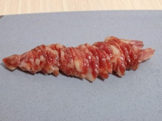 6、懒人煲仔饭--电饭煲版,将腊肠切片备用。冰糖腊肠采用纯精肉、无烟熏、低盐、无味精、不干不柴、健康美味。