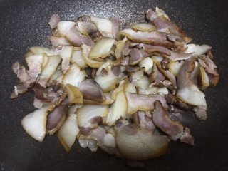 8、腊肉干锅,热锅,少量冷油,因为腊肉里面的肥肉会出油,下腊肉煸炒,水份收干,肉片开始油亮亮的时候,切记不要过了,要不肉过焦、材了不好吃