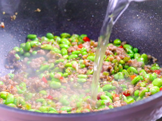 9、最开胃的下饭菜毛豆炒肉末,加入少量的清水，大约150ml，这样就不会导致肉末口感变得干硬。