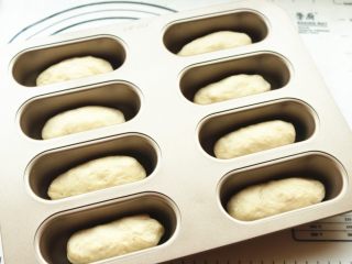 9、香酥粒迷你香蕉热狗,每一份小面团搓圆搓长，放进学厨小热狗模具内。送入烤箱发酵档开始二次发酵，总共可以烤两盘。