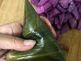 9、紫薯水晶粽,捏紧粽子四周,折扣粽叶,用棉线扎紧。