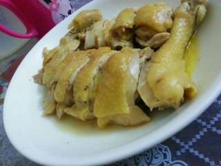 5、姜葱鸡,蒸好的鸡腿从锅拿出来等稍微凉下、把碟中的蒸水气倒了、那蒸水比较咸！然后用刀把它斩块！见图！