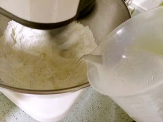 2、紫薯花卷,搅拌均匀后，分次添加清水，开启揉面。