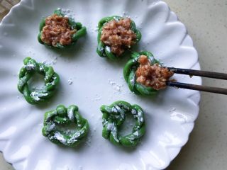 14、肉饼缸豆花环,把拌好的肉末如图码在花环上