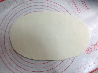 5、芝麻酱红糖饼,把一份面团用手揉圆按扁，擀成椭圆形的薄厚均匀的薄片。