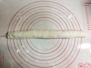 9、芝麻酱红糖饼,把面片如图卷成长条。