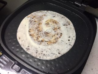 14、芝麻酱红糖饼,把麻酱糖饼放进电饼铛，选择“大饼/油酥饼”程序，火力用速脆，盖上盖子开始烙饼。