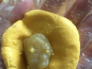 8、奶香南瓜月饼,把馅料包裹起来