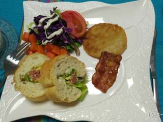 6、法棍全餐,法棍取一段!不是片哦是一段,横向破开不要切断,铺入生菜片生菜片上铺上鸡蛋香肠后挤入酱料我用的是美乃滋!然后用保鲜膜包裹好用刀切成片,摆盘就能上桌吃啦!