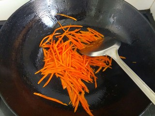 6、鱼香金针菇,锅中放入适量植物油，放入胡萝卜丝，炒出红汤