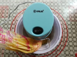 16、酸奶芒果冰淇淋,接通电源后把冰淇淋糊挤入冰淇淋桶里，搅拌20-30分钟(看面糊多少决定)然后放回冰箱冷冻2小时左右（软一点的冻20分钟就可以了）