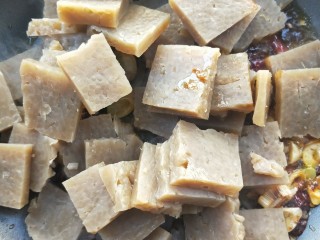 11、门迎百福香辣蒜苗炒焖子,倒入焖子。