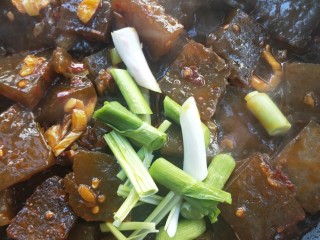 14、门迎百福香辣蒜苗炒焖子,加蒜苗白色部分,再加少许清水,用铲子轻轻把焖子推均匀。