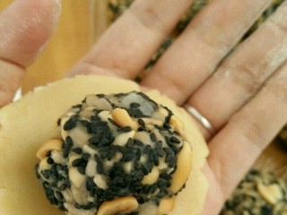 5、五仁馅月饼,拿一个饼皮用手掌稍微压扁，放上五仁馅。