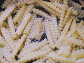 10、川味儿狼牙土豆,倒入土豆,小火翻炒五分钟左右,喜欢软一点的朋友可以多炸一会儿