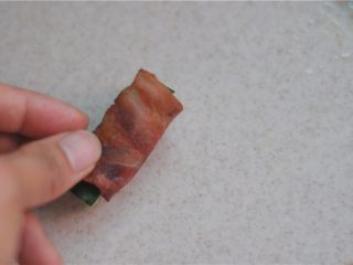 4、芝士土司夹,将煎熟的培根裹上黄瓜条