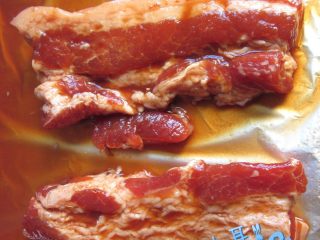 8、港式蜜汁叉烧,预热烤箱,上下火190°,不粘烤盘上垫锡纸,把肉和少许的汁放上去,送进烤箱中层烤30分钟