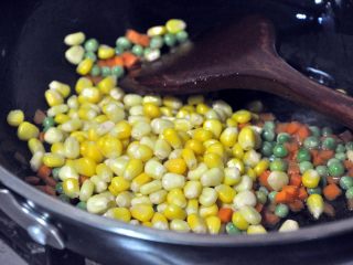 7、松仁玉米,倒入玉米，继续翻炒。