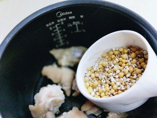 7、黄豆猪脚汤#电饭煲版#,加入泡好的薏米和黄豆。加入清水，适当多一些。我加到了电饭煲的汤功能的中档水位。