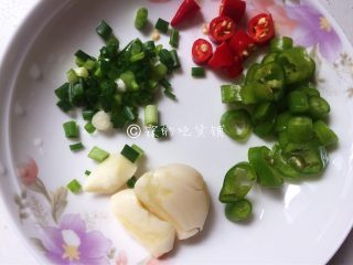 6、拍蒜豉香蒸大肠,准备好葱蒜和辣椒,蒜拍碎、辣椒切圈、葱切葱花。