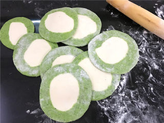 11、翡翠饺子,然后取一个剂子按扁,擀成四周薄中间厚的饺子皮。