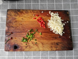 3、蒜蓉粉丝蒸扇贝,蒜切末，小米辣和小葱切圈备用。