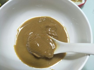 4、自制火锅蘸料,挖四勺芝麻酱放在一个大碗中。