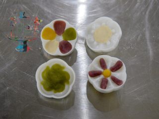 3、好看好玩又好做的颜值担当——桃山皮月饼,取少量的不同颜色的桃山皮，在花片上你喜欢的位置，薄薄的按压一层。不可以贪心按压的太厚太多。