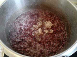 7、自制红豆沙,再次打开煤气灶 调制到最小火 倒入冰糖。