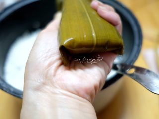 3、蜜枣白米甜粽,同时两侧粽叶顺着上窄下宽的形状折叠。