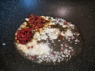 3、啤酒小龙虾,锅里多放一点油，把蒜先炒香。然后在加郫县豆瓣酱，佐餐酱翻炒。