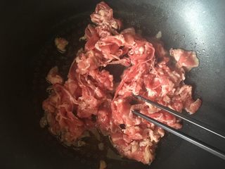 8、小牛饭便当,热锅凉油，下入肉卷，用筷子不停划拉，防止粘连，炒到全部变熟