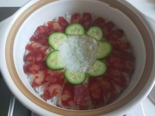 8、广式煲仔饭,摆放一圈腊肠，在摆黄瓜片，中间用勺子压一个坑。