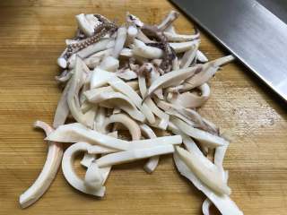 3、铁板鱿鱼,把焯过水的鱿鱼切成细条。