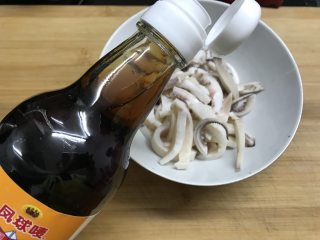 4、铁板鱿鱼,加半勺生抽，半勺蚝油，料酒，鱼露拌匀后腌10分钟。